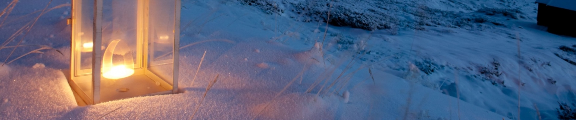 Lanterne éclairée dans la neige au crépuscule